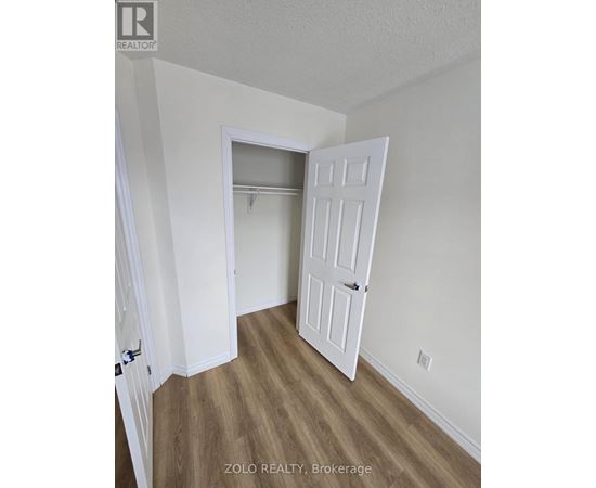 A room with a white door and a wooden floor.