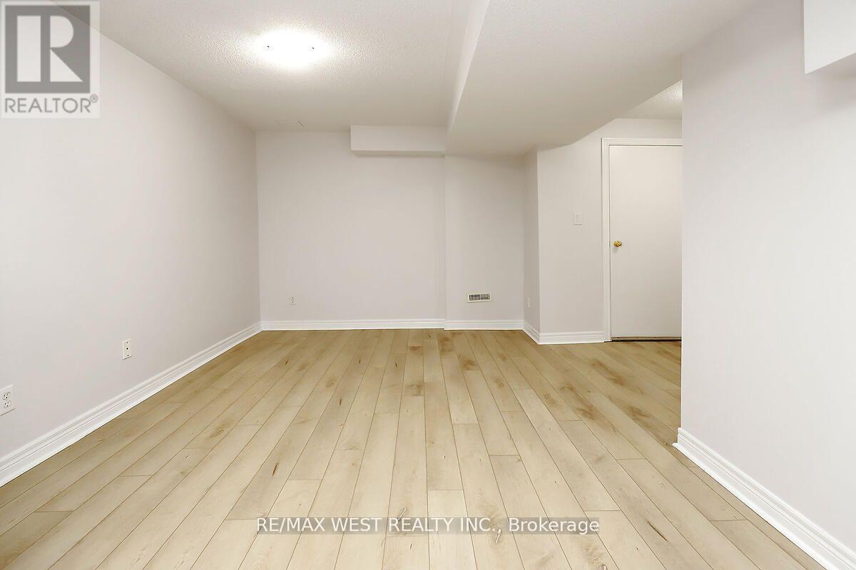 A room with wooden flooring and white walls.