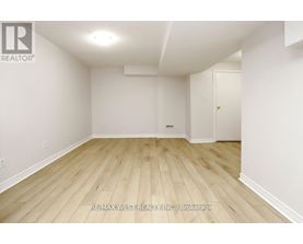 A room with wooden flooring and white walls.