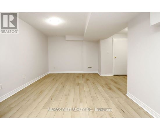 A room with wooden flooring and white walls.