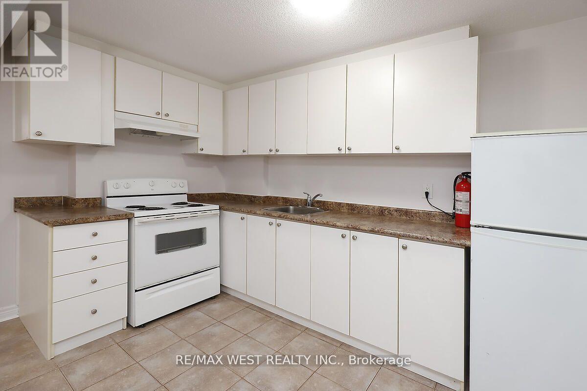 A kitchen with white appliances and cabinets.