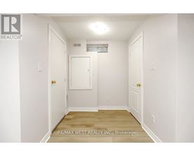 A white hallway with a door on the left and a door on the right.
