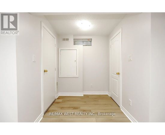 A white hallway with a door on the left and a door on the right.