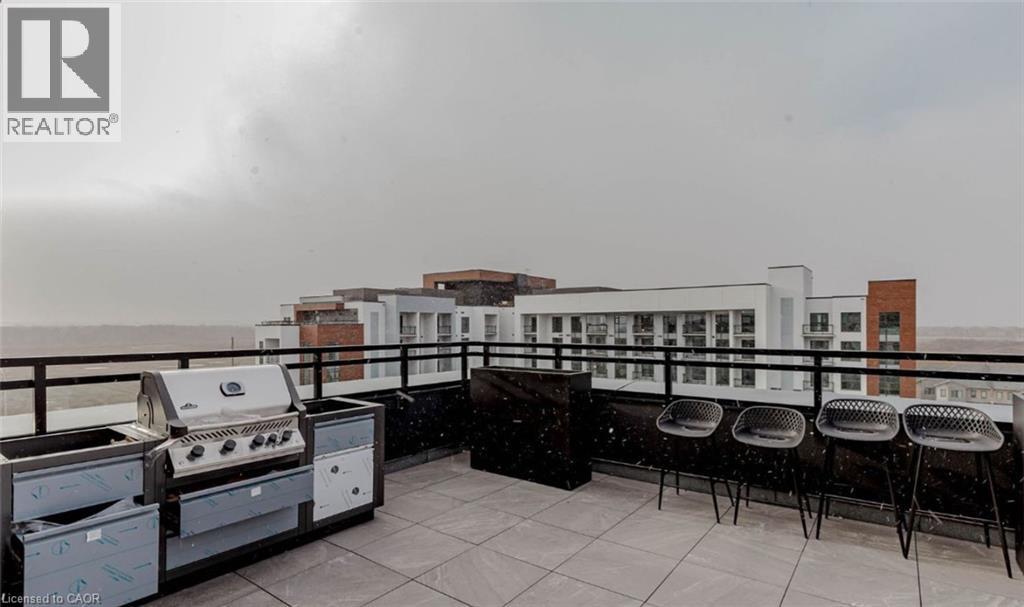 A balcony with barbecue grills and chairs overlooking a cityscape.