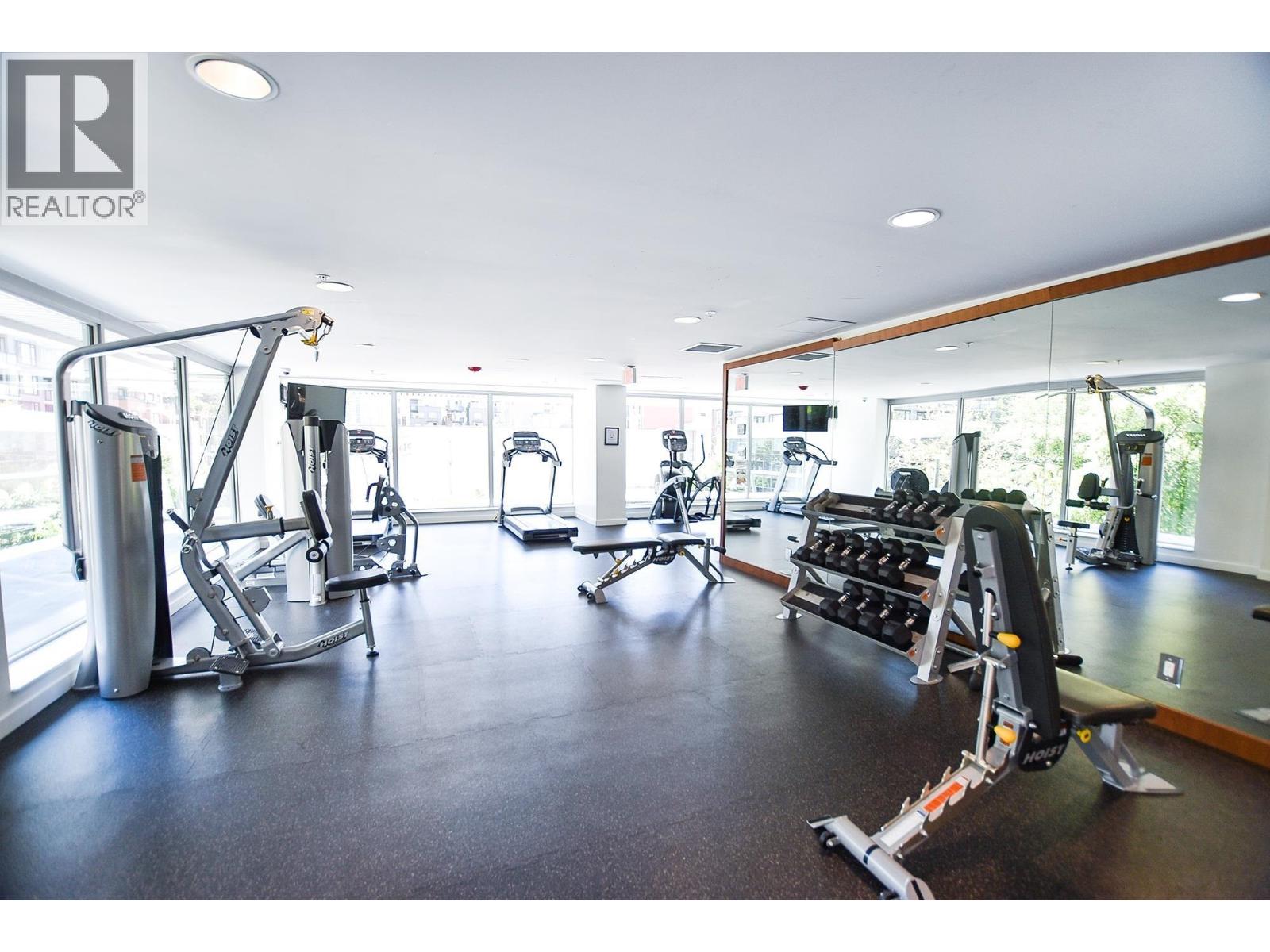 A gym with a variety of equipment including treadmills, weights, and exercise machines.