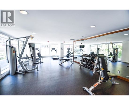 A gym with a variety of equipment including treadmills, weights, and exercise machines.
