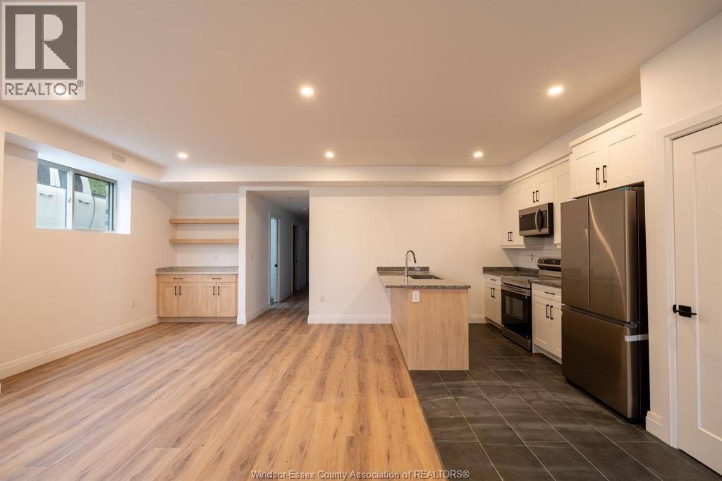 A spacious room with wooden flooring and white walls.