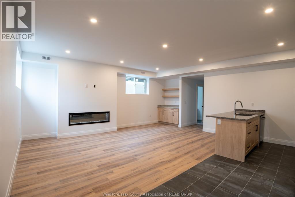 A white room with a fireplace and wood flooring.