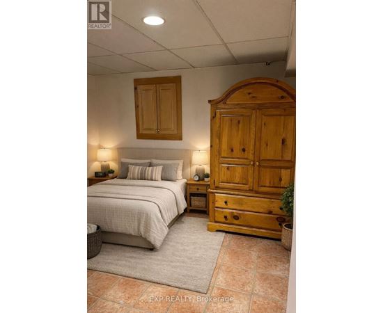 A bedroom with a bed, nightstand, and wardrobe.