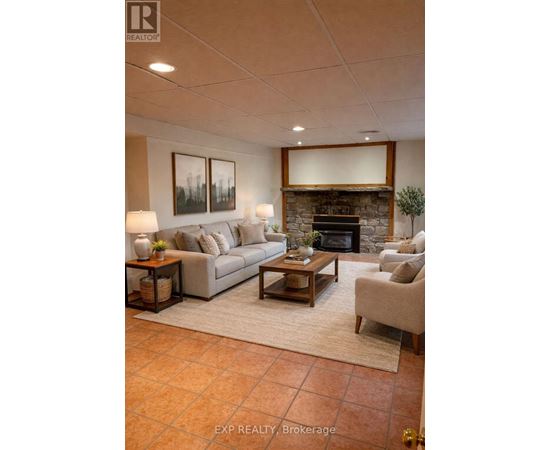 A living room with a couch, a chair, a coffee table, and a fireplace.