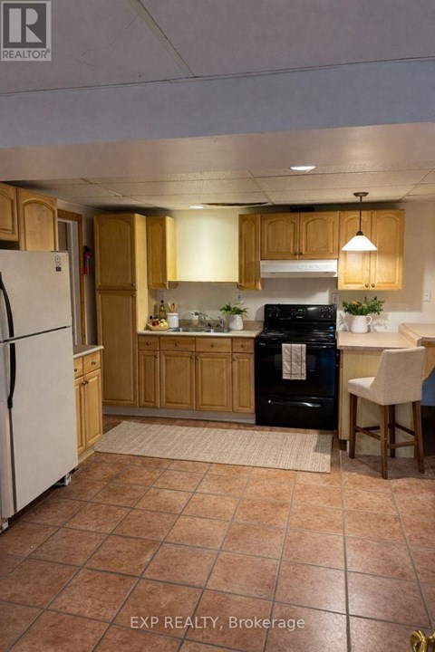A kitchen with tile flooring and wooden cabinets.