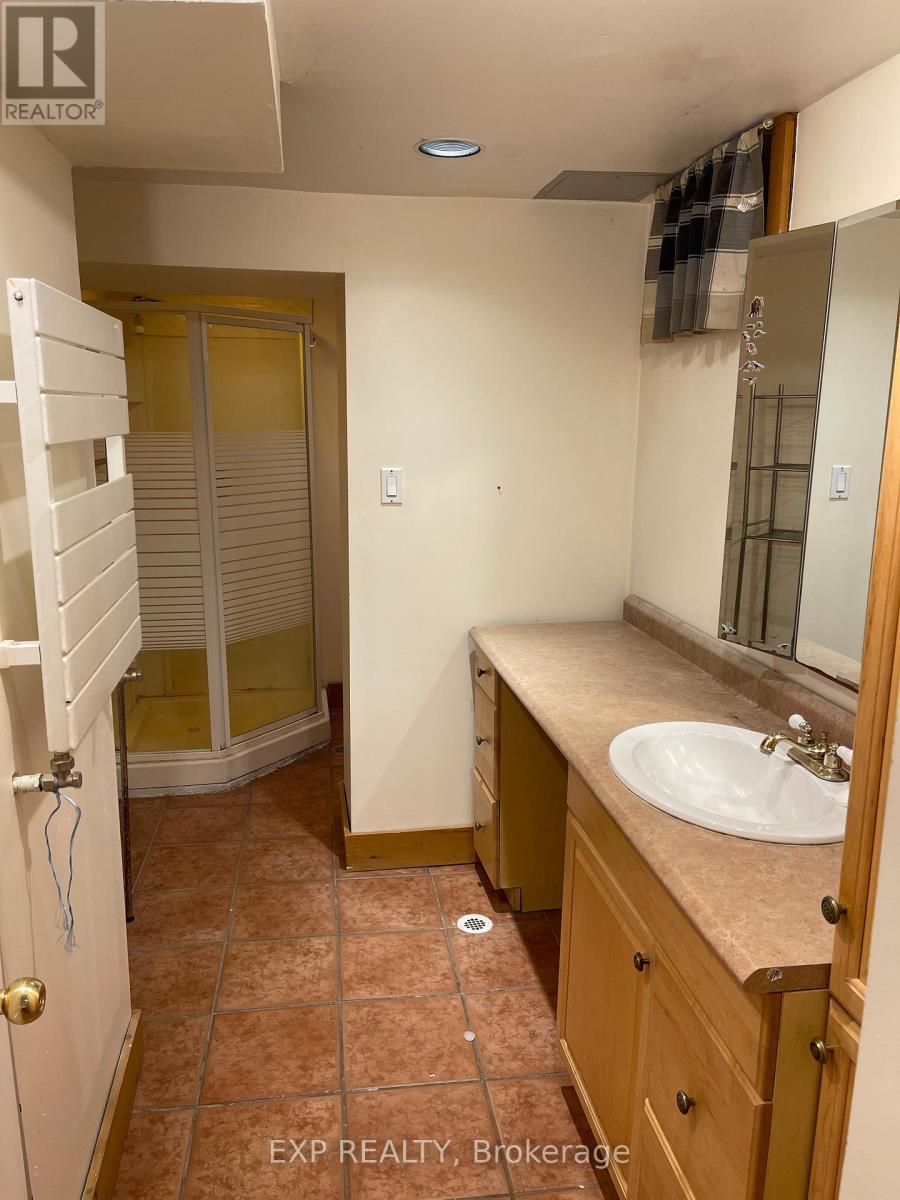 A bathroom with a sink, mirror, and a shower with a glass door.