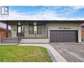 A house with a garage and a sign that says "7537 Lutty Court".