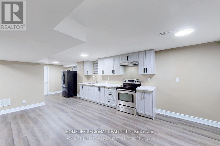 A spacious kitchen with white cabinets and stainless steel appliances.