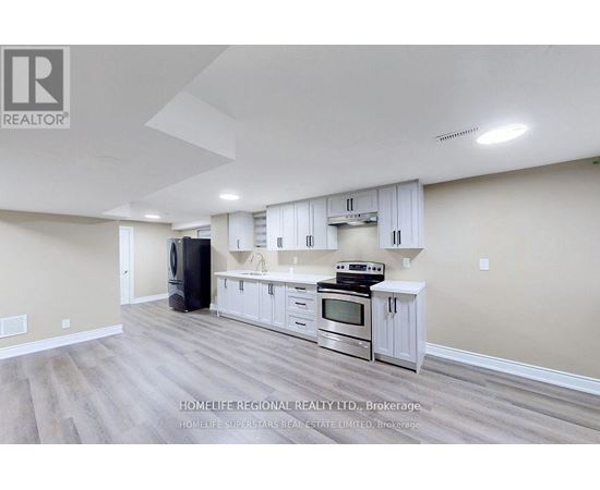 A spacious kitchen with white cabinets and stainless steel appliances.