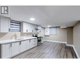 A kitchen with white cabinets and a wooden floor.