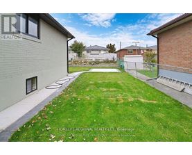 A backyard with a fence and a grassy area.