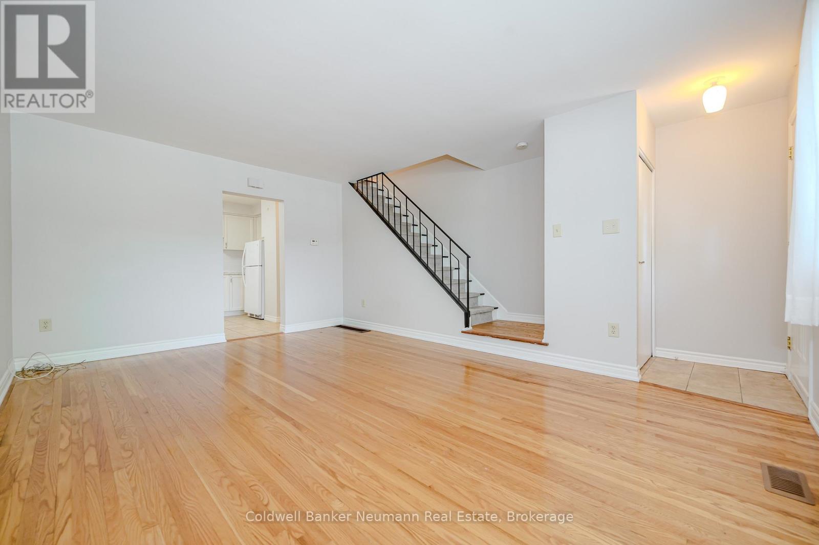 A room with wooden floors and a staircase.