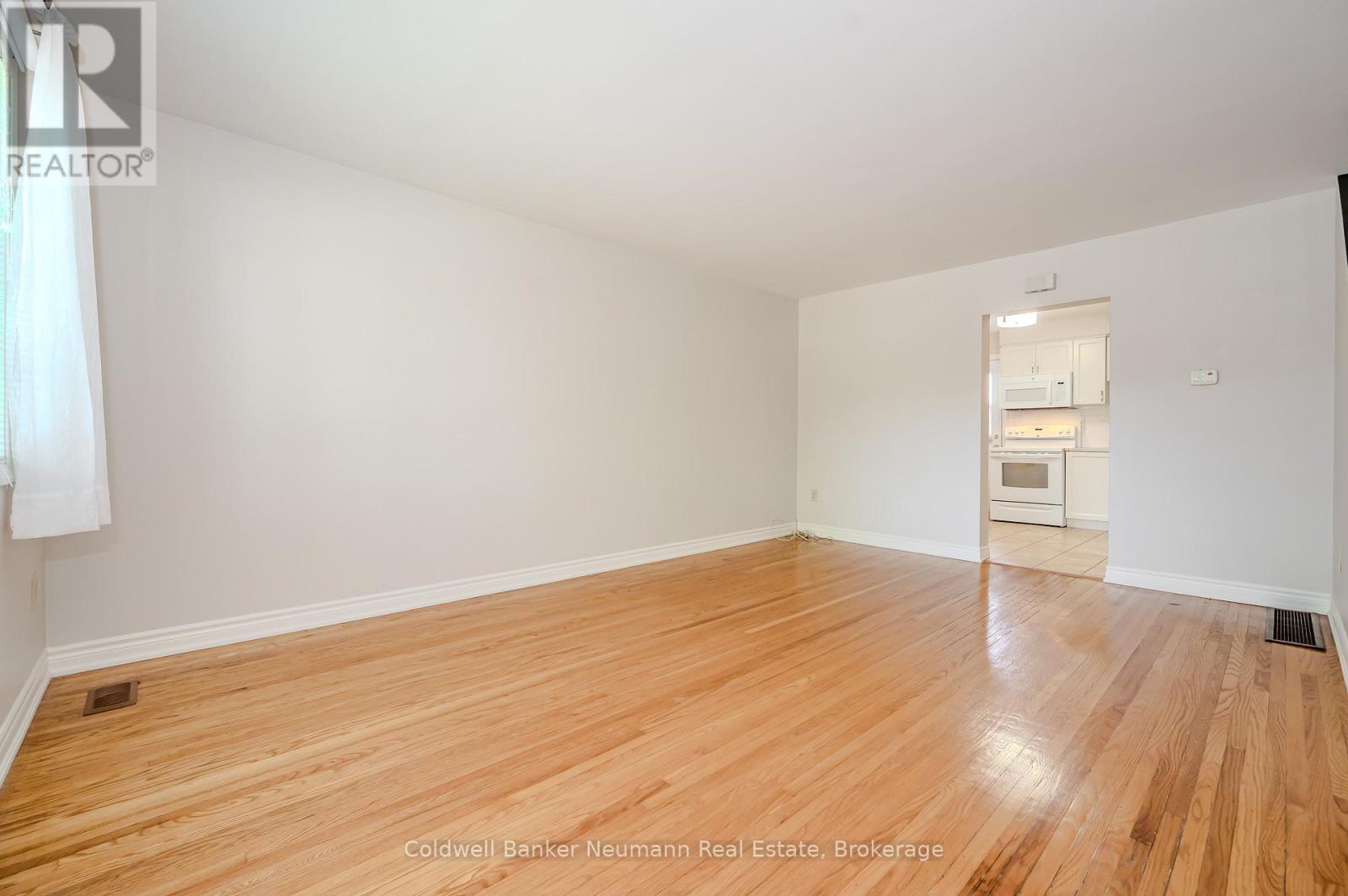 A room with wooden flooring and a white wall.