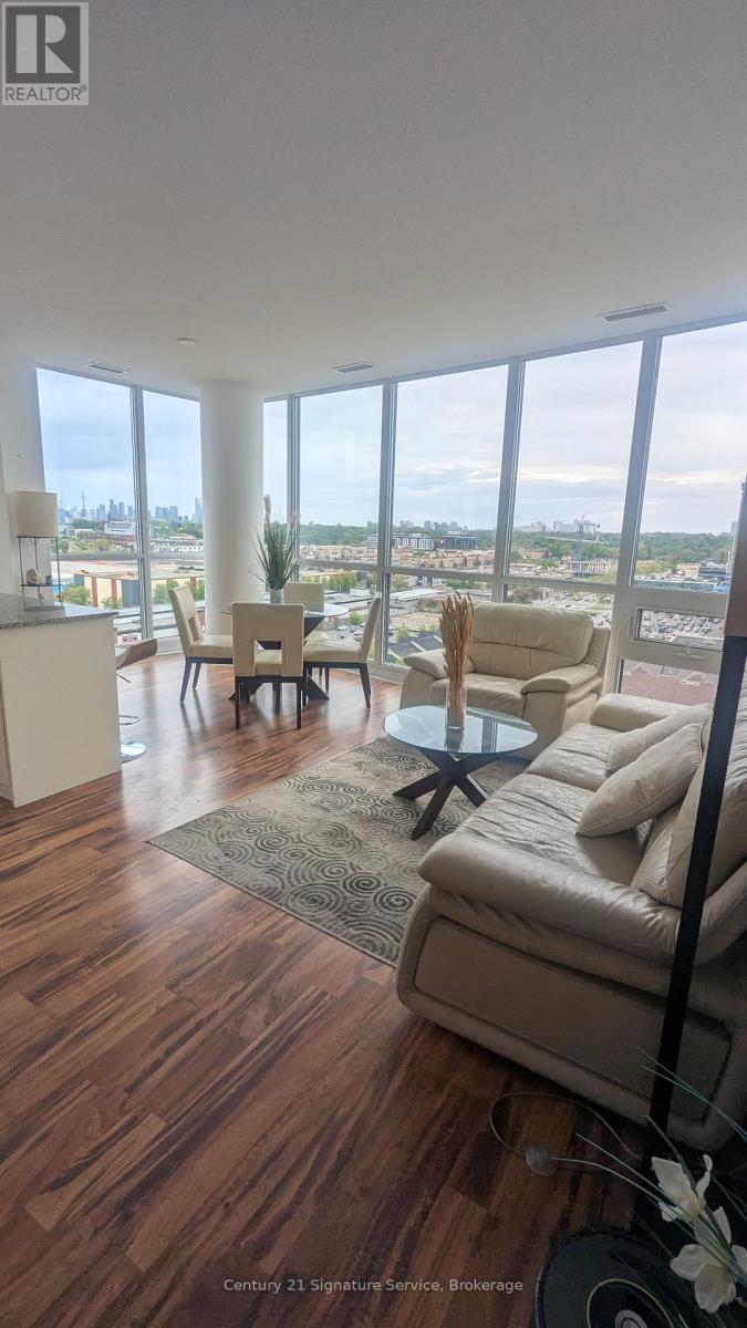 A kitchen with white cabinets and a view of the city.