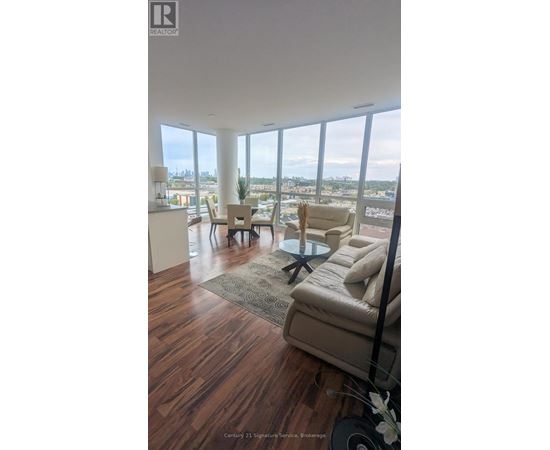 A kitchen with white cabinets and a view of the city.