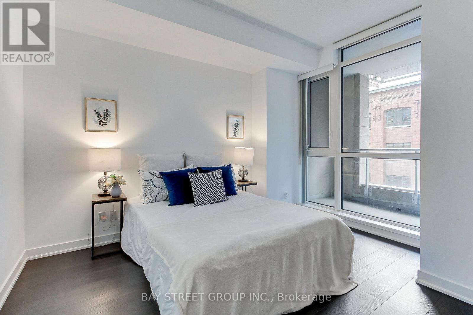 A bedroom with a bed, nightstands, and a window.