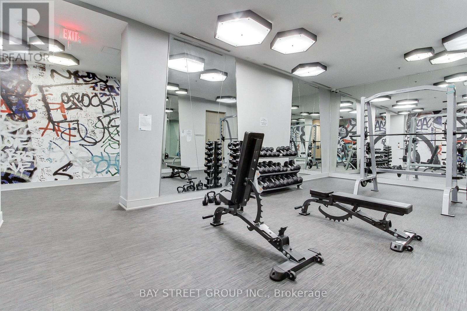 A gym with a variety of equipment including a squat rack, bench and weights.