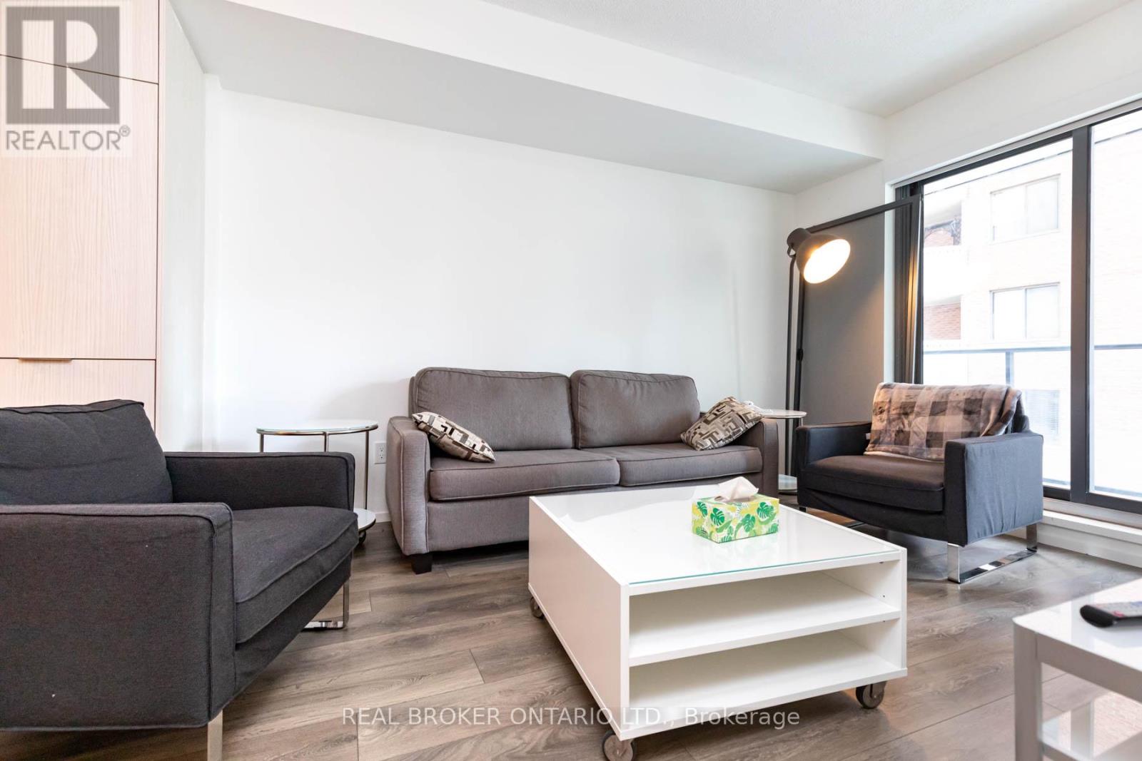 A living room with a grey couch and a white coffee table.