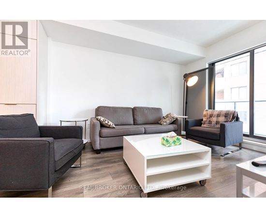 A living room with a grey couch and a white coffee table.