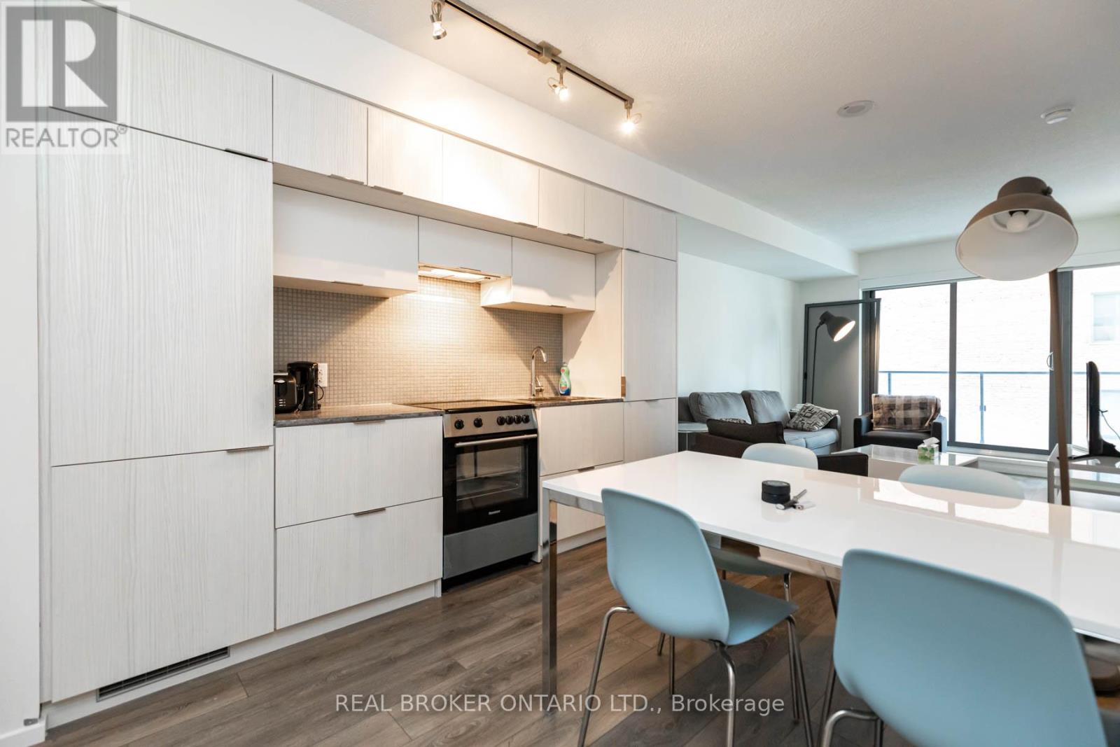 A modern kitchen with white cabinets and a dining table.