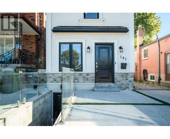 A modern house with a black front door and a glass railing.