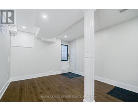 A spacious room with wooden floors and white walls.