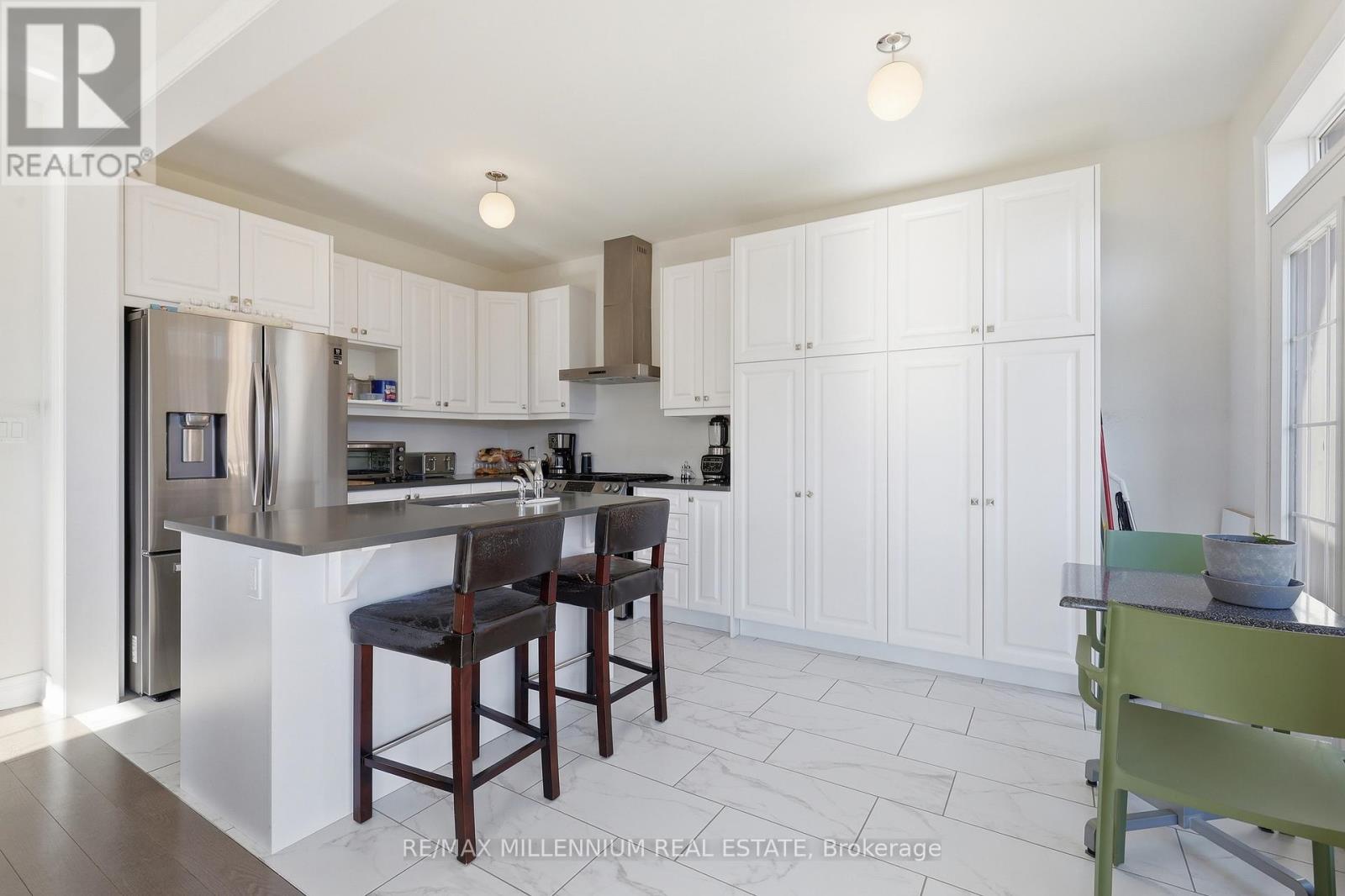 A kitchen with white cabinets and a wooden island.