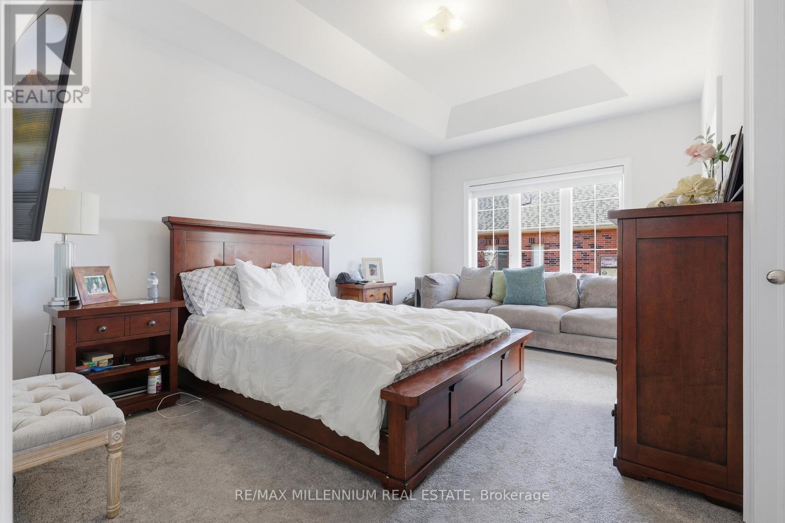 A bedroom with a large bed and a couch in the background.