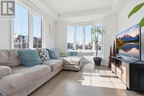 A living room with a grey couch and a flat screen TV.