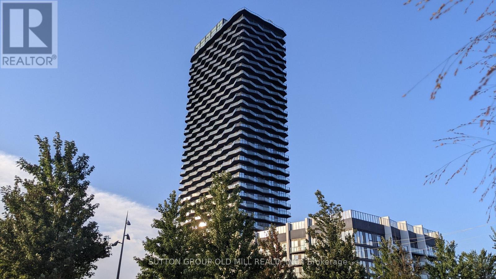 A tall building with a pattern of windows stands in front of a clear blue sky.