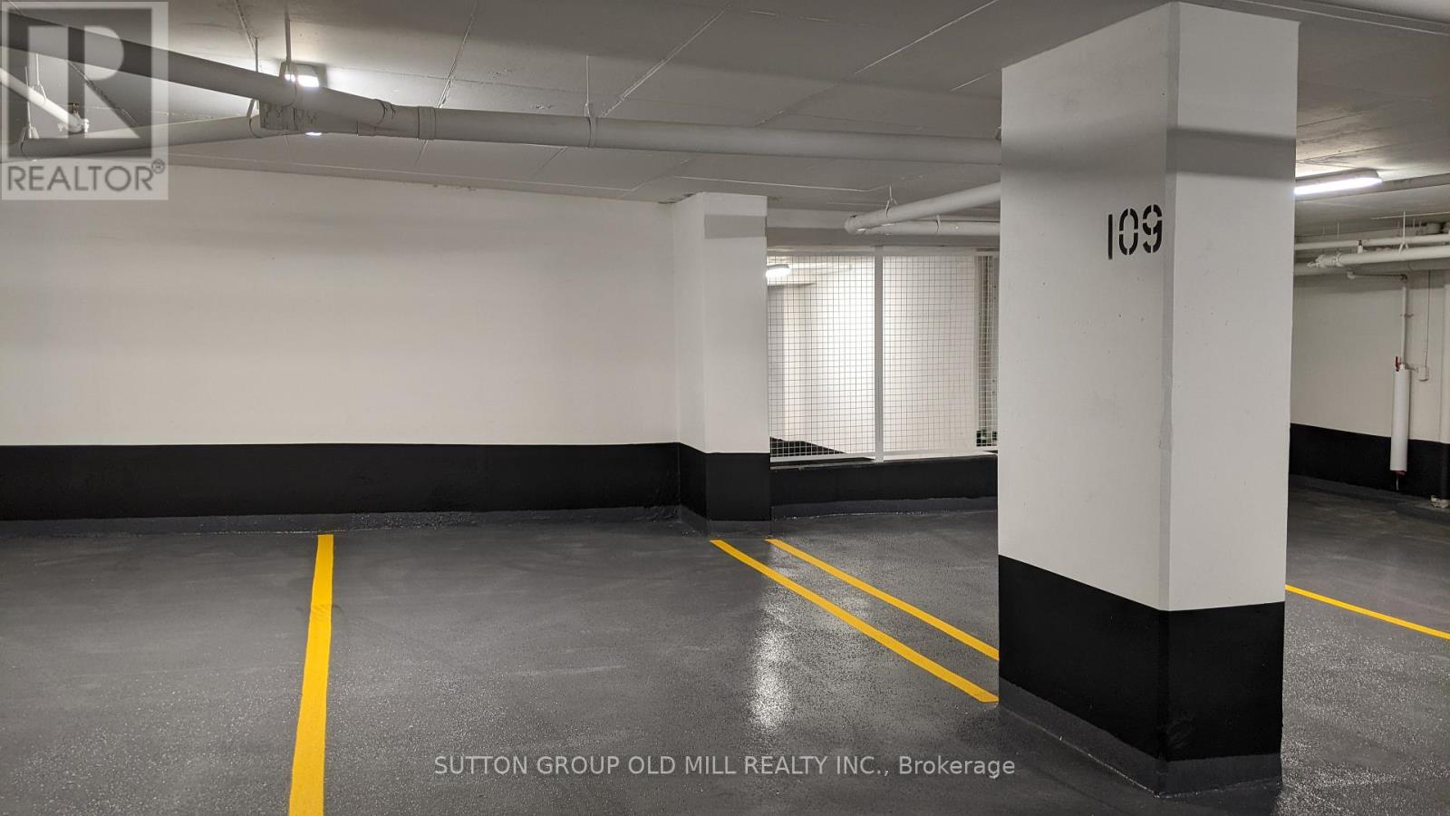 A spacious, empty parking garage with yellow lines on the floor.