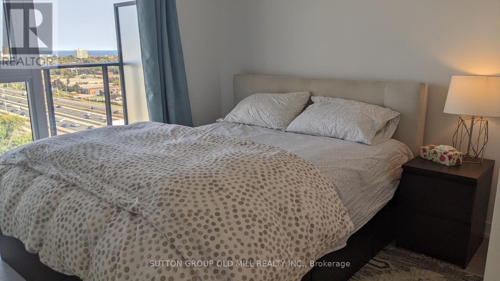 A bedroom with a large bed and a view of the city.