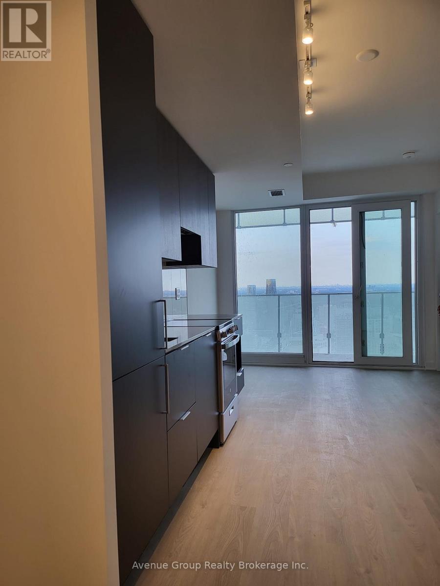 A modern kitchen with wooden floors and a large window.