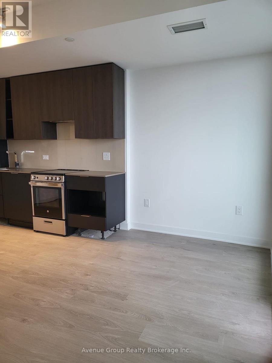 A kitchen with dark brown cabinets and a stove top oven.