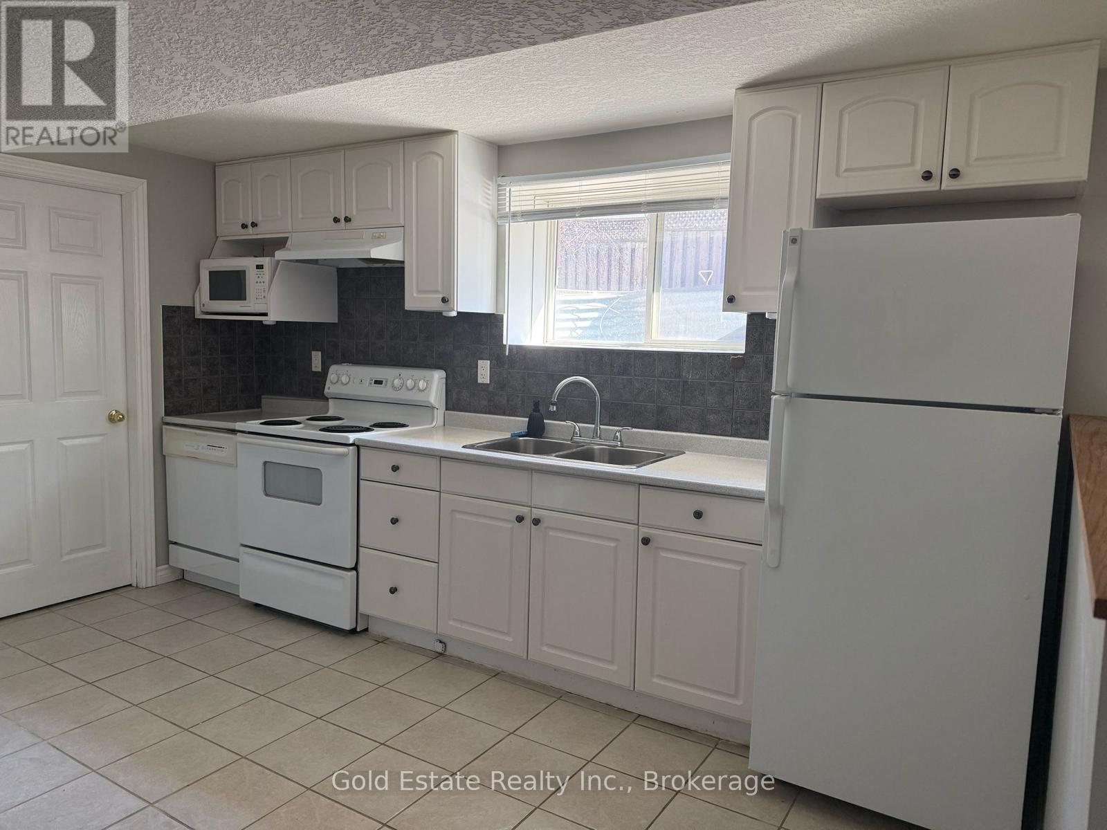 A kitchen with white appliances and cabinets.