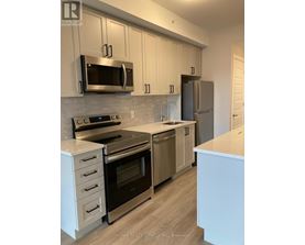 A modern kitchen with stainless steel appliances and white cabinets.