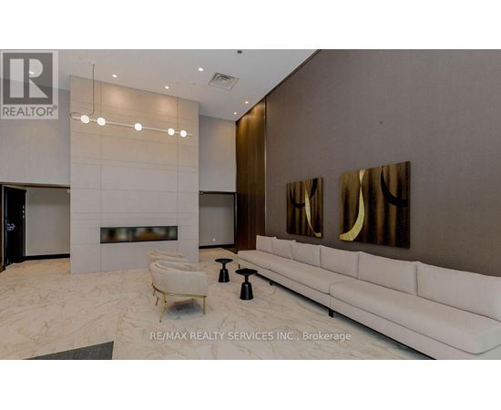 A modern living room with a white sofa and a fireplace.