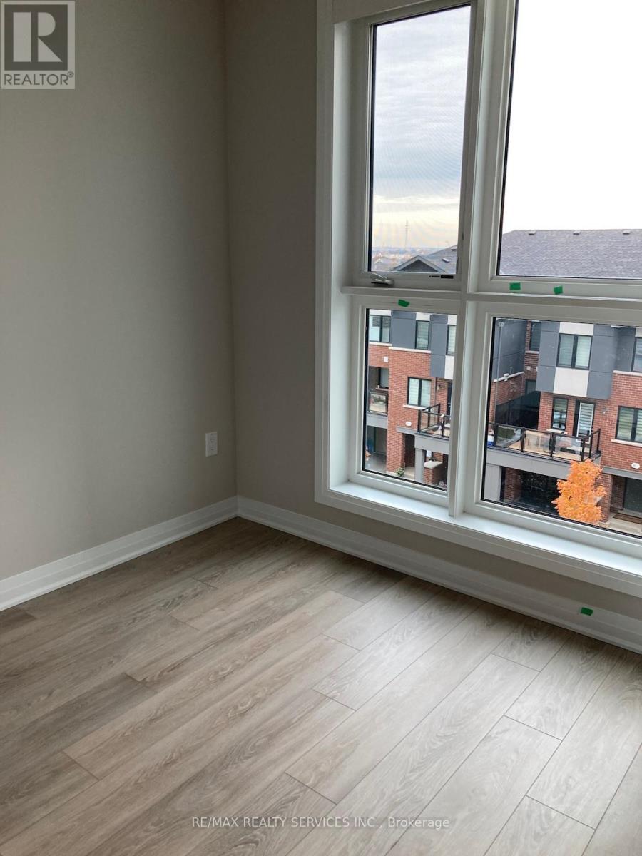 A room with a large window overlooking a residential area.
