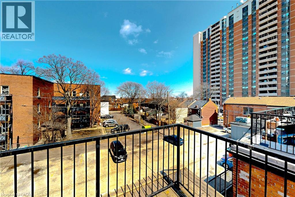 A balcony overlooks a parking lot and buildings.