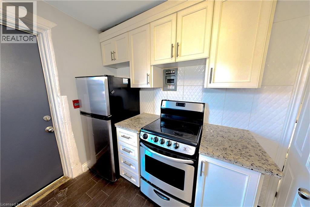 A kitchen with a stove, oven, and refrigerator.