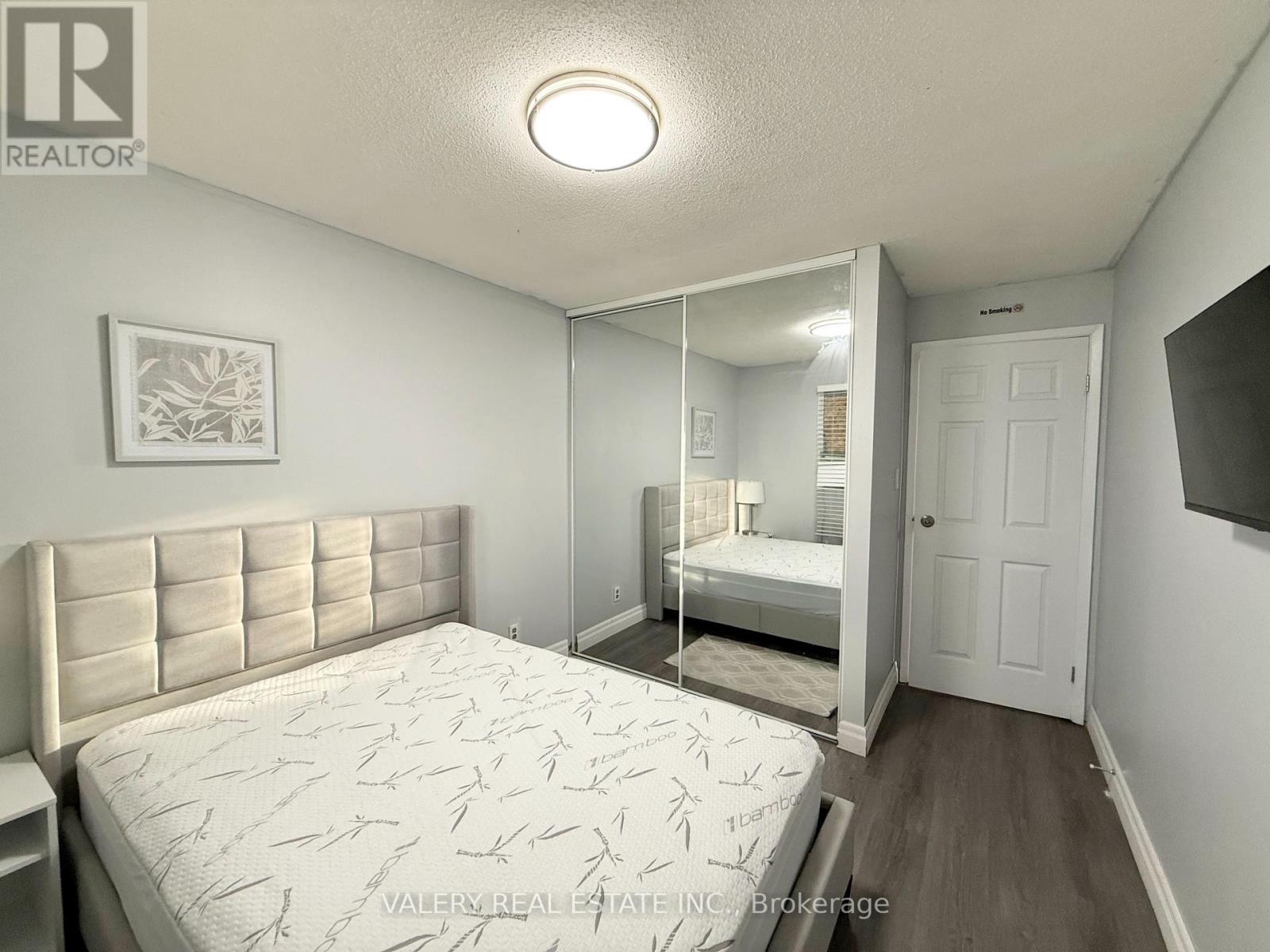A bedroom with a large bed and a mirror on the wall.