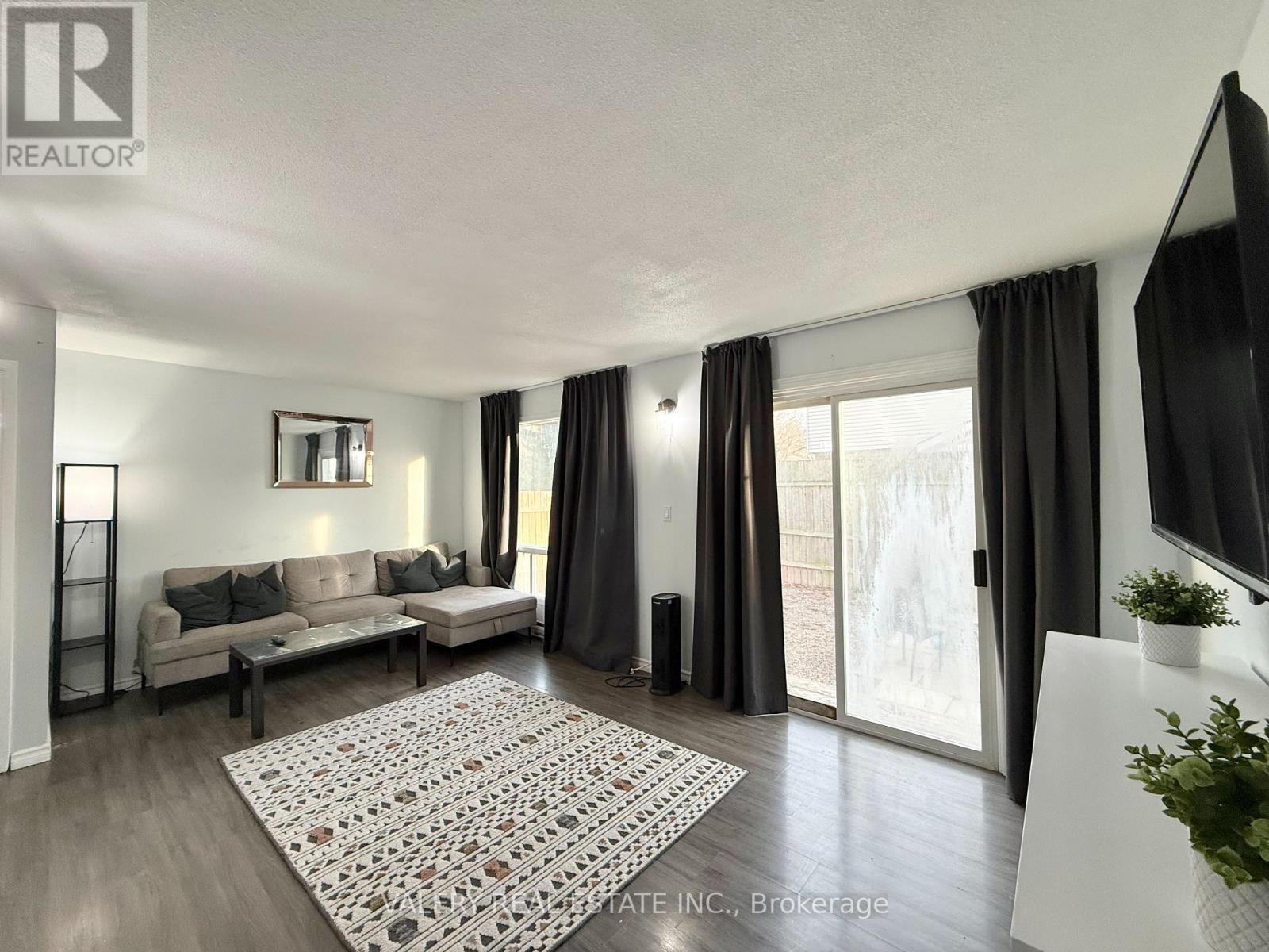 A living room with a couch, a rug, and a television.