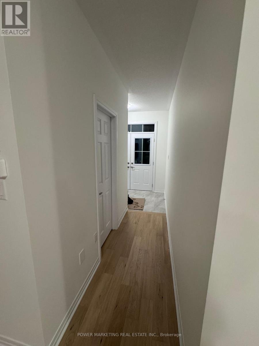 A long hallway with white walls and wood floors.