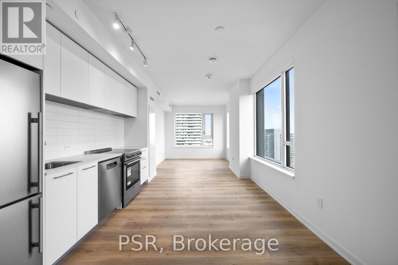 A modern kitchen with white cabinets and stainless steel appliances.